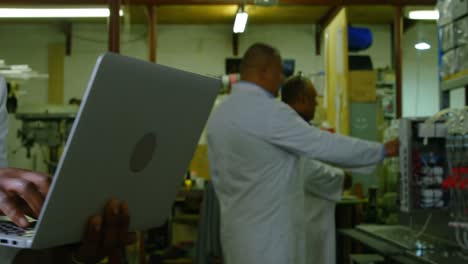 Trabajador-Usando-Laptop-En-Fábrica-De-Vidrio-4k