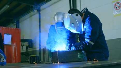 Robotic-engineers-welding-metal-in-robotic-warehouse-4k