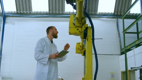 Robotic-engineer-examine-robotic-machine-in-warehouse-4k
