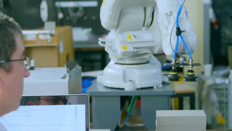 Robotic-engineer-examine-robotic-machine-in-warehouse-4k