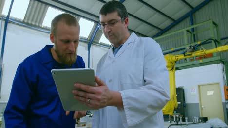 Robotic-engineers-discussing-over-digital-tablet-4k