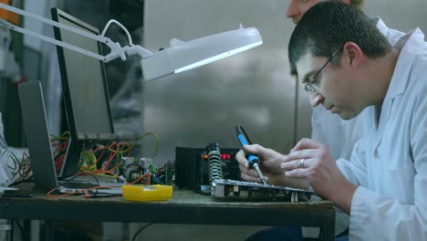 Robotic-engineer-assembling-circuit-board-at-desk-4k