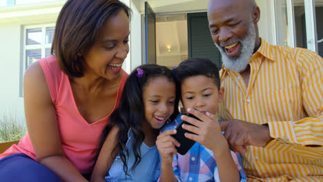 Vorderansicht-Einer-Schwarzen-Familie,-Die-Ihr-Mobiltelefon-In-Einem-Komfortablen-Zuhause-Nutzt,-4K
