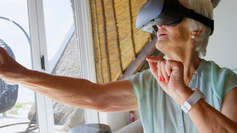 Vista-Frontal-De-Una-Anciana-Caucásica-Usando-Auriculares-De-Realidad-Virtual-En-Un-Hogar-Cómodo-4k