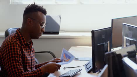 Side-view-of-young-cool-mixed-race-business-team-working-at-desk-in-a-modern-office-4k