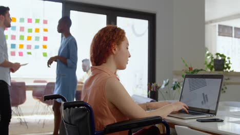 Side-view-of-disable-young-caucasian-businesswoman-working-on-laptop-in-a-modern-office-4k