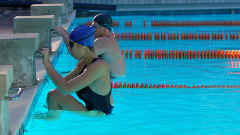 Side-view-of-man-and-woman-swimming-in-the-pool-4k