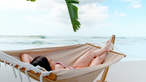 Young-caucasian-woman-sleeping-in-hammock-at-beach-4k