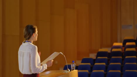 Young-Caucasian-businesswoman-practicing-speech-in-empty-auditorium-4k