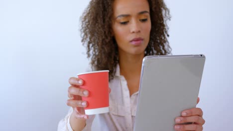 Hübsche-Weibliche-Führungskraft-Gemischter-Abstammung,-Die-Kaffee-Trinkt-Und-Ein-Digitales-Tablet-In-Einem-Modernen-Büro-4-4k-Verwendet