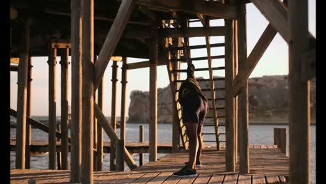 African-American-male-jogger-exercising-on-pier-on-the-beach-4k