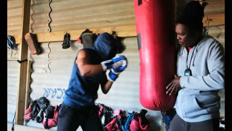 Afroamerikanischer-Boxer-übt-Boxen-Mit-Trainer-Im-Fitnessstudio-4k