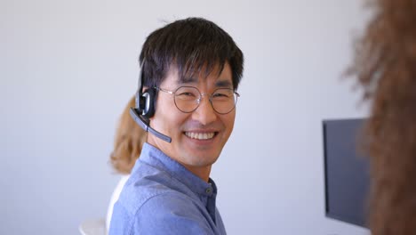 Junge-Asiatische-Männliche-Kundenvertriebsleiter-Sprechen-über-Headset-Im-Modernen-Büro-4k