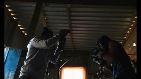 African-American-male-boxer-practicing-boxing-with-trainer-in-gym-4k
