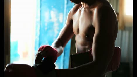 African-American-male-boxer-wearing-boxing-gloves-in-fitness-studio-4k