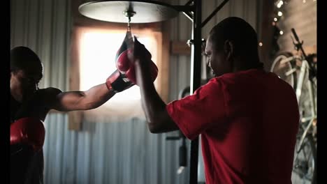 Boxeador-Afroamericano-Practicando-Boxeo-Con-Entrenador-En-Gimnasio-4k