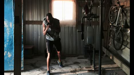 Young-African-American-male-boxer-practicing-boxing-in-fitness-studio-4k