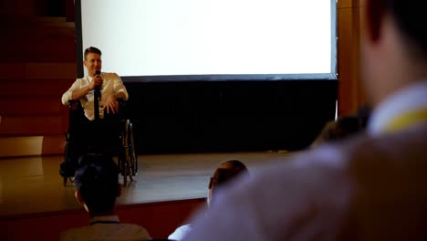 Young-Caucasian-disabled-businessman-speaking-in-business-seminar-in-auditorium-4k