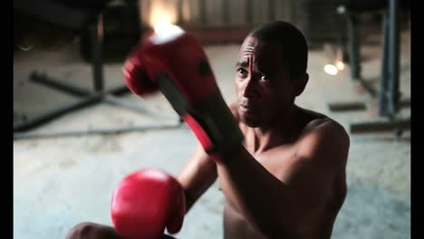 African-American-male-boxer-practicing-boxing-with-trainer-in-fitness-studio-4k