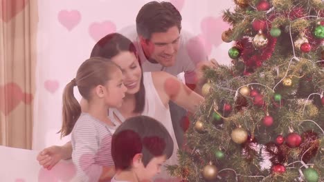 Animation-of-family-decorating-the-Christmas-tree-against-of-pink-heart