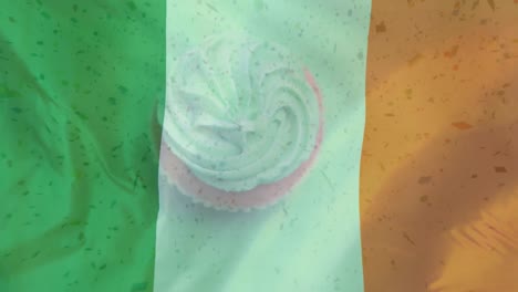 Muffin-Rotiert-Auf-Einem-Irischen-Flaggenhintergrund-Mit-Fallenden-Digitalen-Partikeln