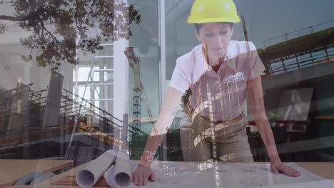 Female-architect-looking-at-blueprints-with-construction-site-