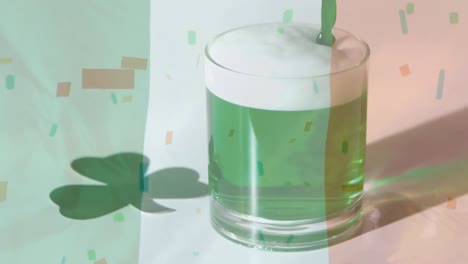 Green-beer-in-a-glass-with-confetti-falling-on-the-foreground