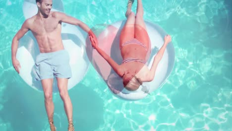 Couple-lying-on-float-in-pool