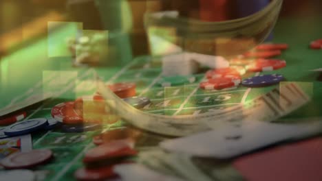 Game-cards,-chips,-and-cash-falling-on-roulette-table-and-squared-lights-on-the-foreground-in-casino