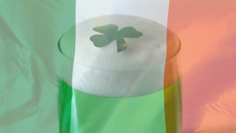 Shamrock-falling-on-a-green-beer-against-an-Irish-flag-background-for-St-Patrick-Day