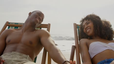 Front-view-of-African-american-couple-having-fun-together-on-the-beach-4k