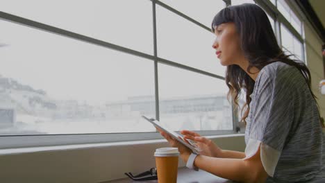 Businesswoman-using-digital-tablet-near-window-in-a-modern-office-4k