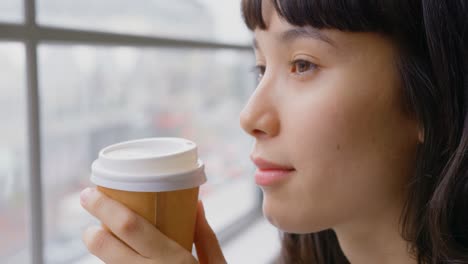Businesswoman-drinking-coffee-while-sitting-near-window-in-a-modern-office-4k