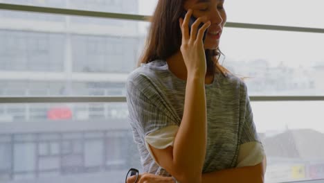Mujer-De-Negocios-Hablando-Por-Teléfono-Móvil-En-Una-Oficina-Moderna-4k