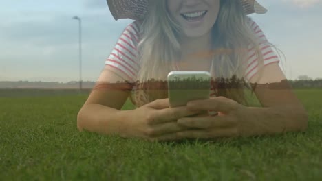 Woman-lying-on-grass-texting-on-her-phone