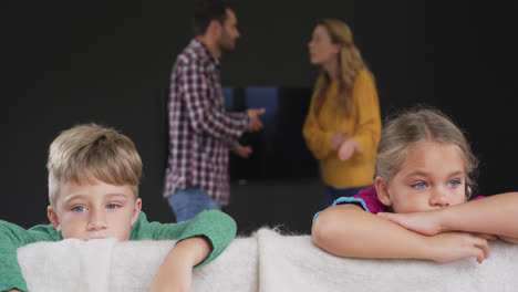 Kids-leaning-on-sofa-while-parents-arguing-in-background-at-home-4k