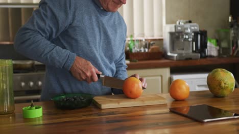 Senior-man-cutting-fruits-at-home