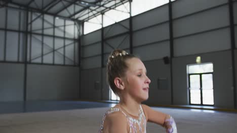 Teenage-female-gymnast-performing-at-sports-hall