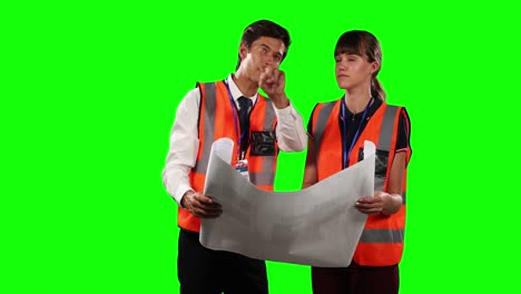 Front-view-of-a-site-workers-looking-at-a-site-map-with-green-screen-