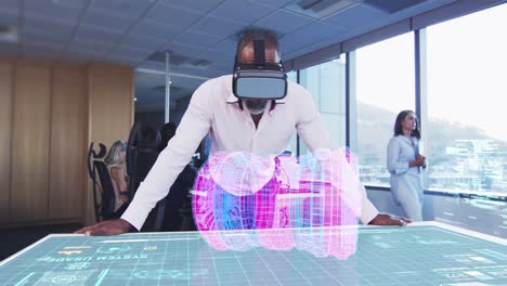 Animation-of-a-businessman-wearing-a-VR-headset-with-a-3d-plan-on-a-table