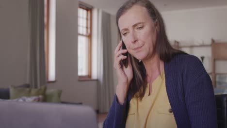 Mujer-Hablando-Por-Teléfono-Inteligente-En-Casa