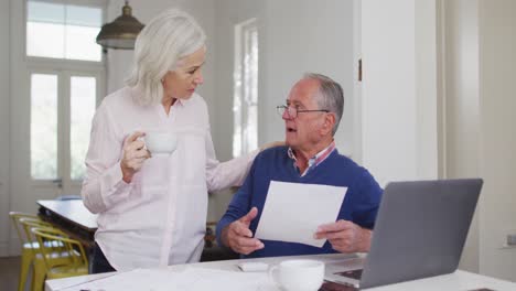 Älteres-Paar-Mit-Kaffeetasse,-Laptop-Benutzend-Und-Zu-Hause-Finanzen-überprüfend