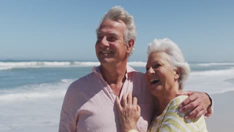 Happy-senior-caucasian-couple-with-arms-around-each-other-embracing-each-other-on-the-beach