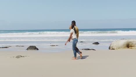 African-american-couple-holdings-hands-and-walking-at-the-beach