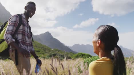 African-american-couple-high-fiving-each-other-while-trekking-in-the-mountains
