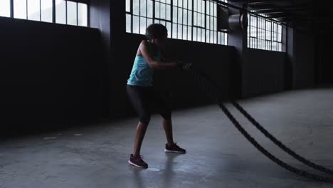 African-american-woman-exercising-battling-ropes-in-an-empty-urban-building