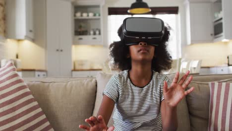 African-american-girl-sitting-on-couch-wearing-vr-headset