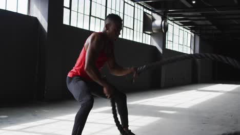 African-american-man-exercising-battling-ropes-in-an-empty-urban-building