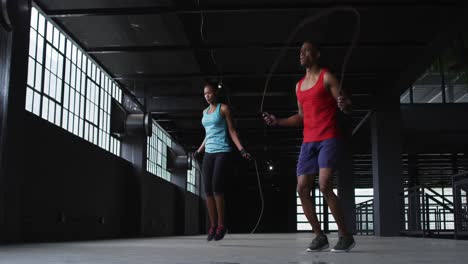 African-american-man-and-woman-skipping-rope-in-an-empty-urban-building