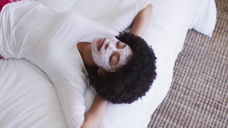 Afroamerikanische-Frau-Mit-Gesichtsmaske,-Die-Auf-Dem-Bett-Liegt